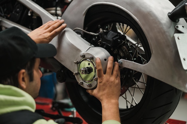 Man fixing a motorcycle in a modern workshop