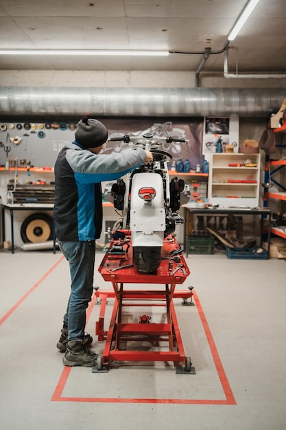 Man fixing a motorcycle in a modern workshop