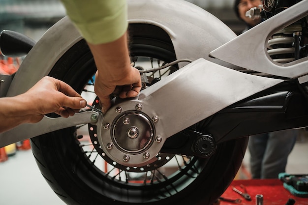 Man fixing a motorcycle in a modern workshop