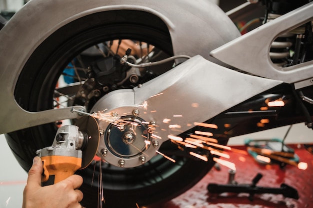 Man fixing a motorcycle in a modern workshop