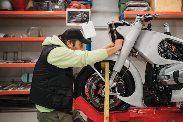 Man fixing a motorcycle in a modern workshop