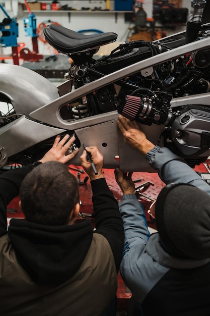 Man fixing a motorcycle in a modern workshop