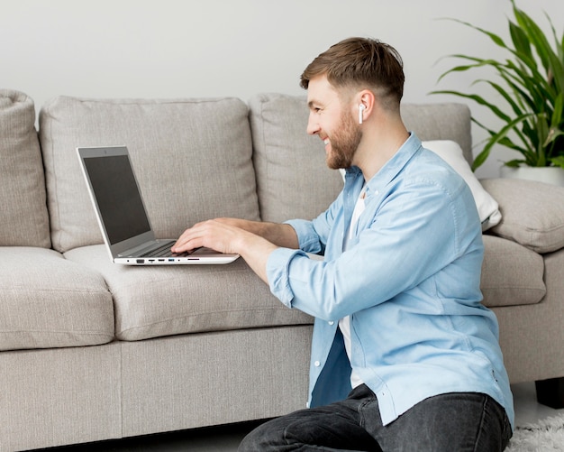 Uomo sul pavimento che lavora al computer portatile