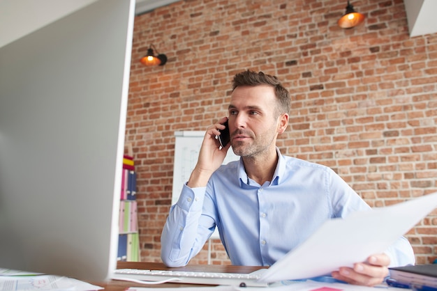 Foto gratuita l'uomo si è concentrato mentre si lavora al computer