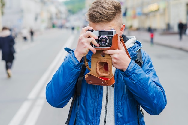 Foto gratuita l'uomo che messa a fuoco con la macchina fotografica