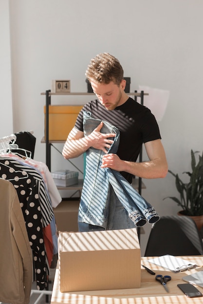 Man folding denim shirt