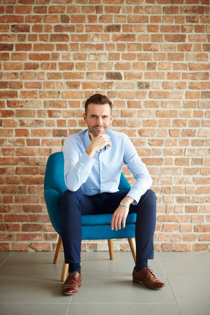 Man in formal clothes sitting in armchair