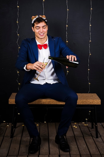 Free photo man in fox mask on head with glass and bottle of champagne