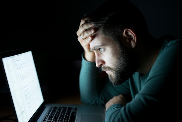 Man in front of the laptop reading and being concentrated