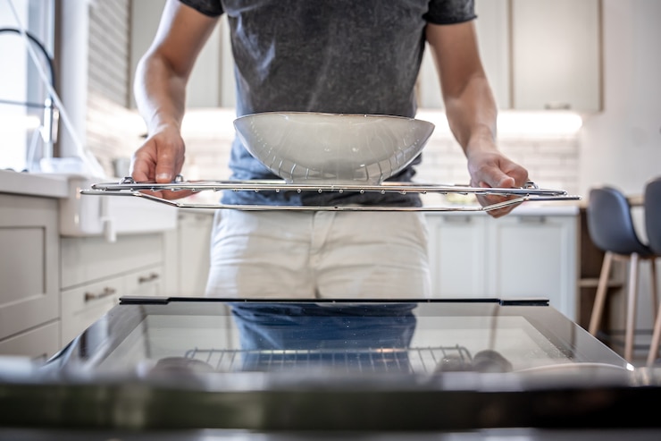 Free Photo a man in front of an open dishwasher with a plate.