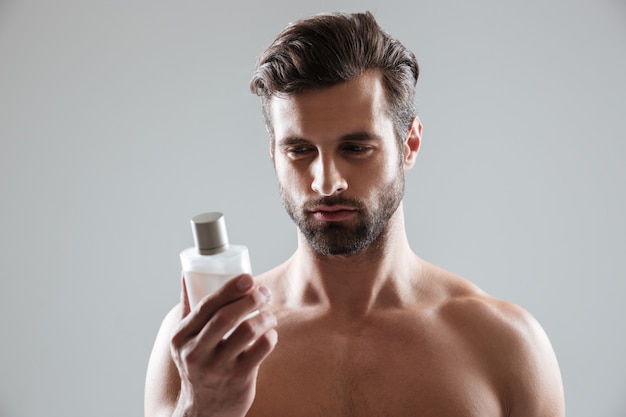 Man gazing at bottle of perfume isolated Free Photo
