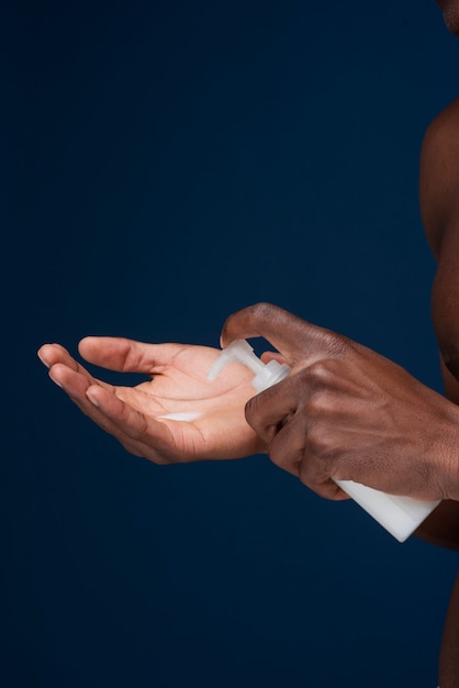 Free photo man getting face cream out of the bottle