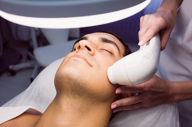 Man getting a facial massage at clinic