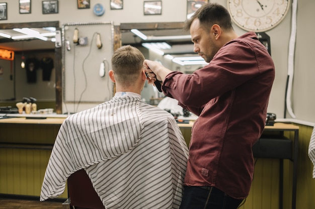 Uomo che ottiene un taglio di capelli in un barbiere