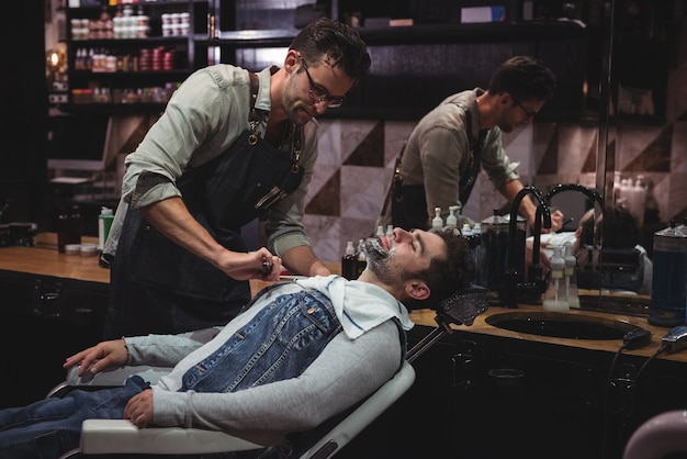 Man getting his beard shaved with razor