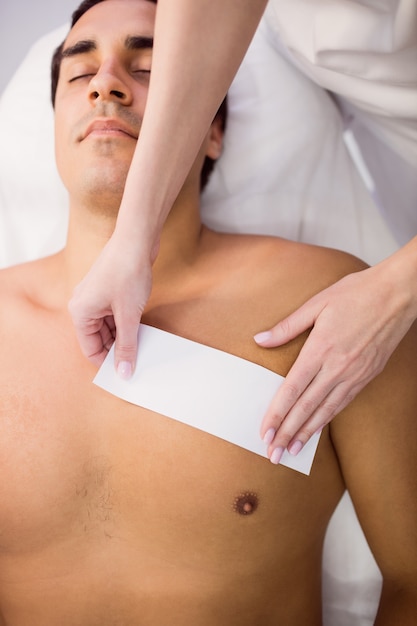 Man getting his chest waxed with wax strip