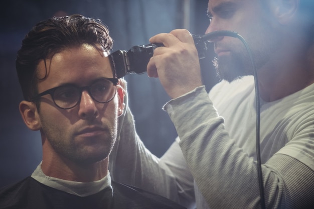 Uomo che ottiene i suoi capelli tagliati con trimmer