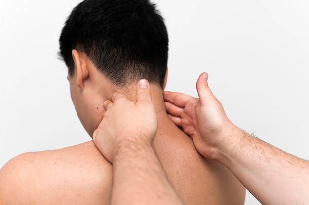 Мужчина получает массаж шеи от физиотерапевта