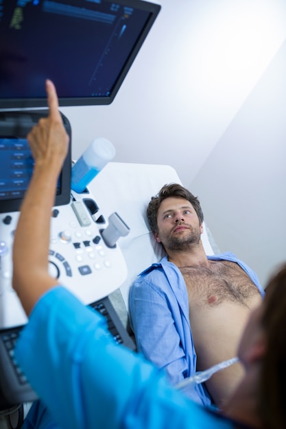 無料写真 医者から腹部の超音波検査を受ける男性