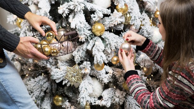 Man and girl decorating christmas tree