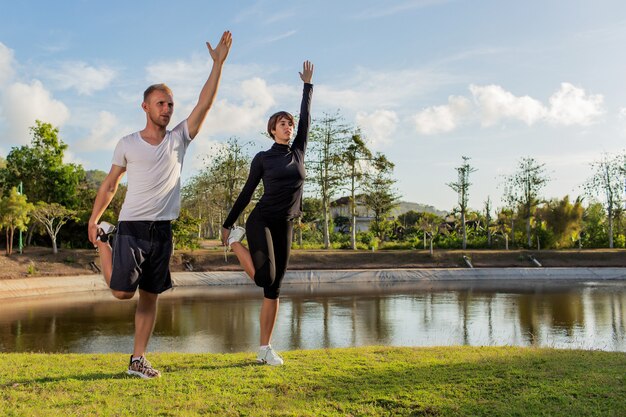 公園でウォームアップをしている男と女。