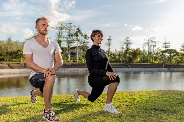 Man and girl doing warm-up in the park.