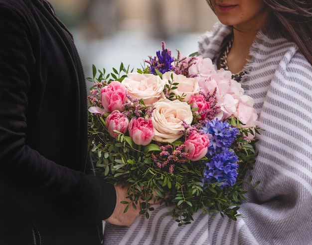 混合花の花束を女性に与える男