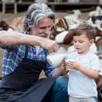 Foto gratuita uomo che dà al latte di capra del ragazzo