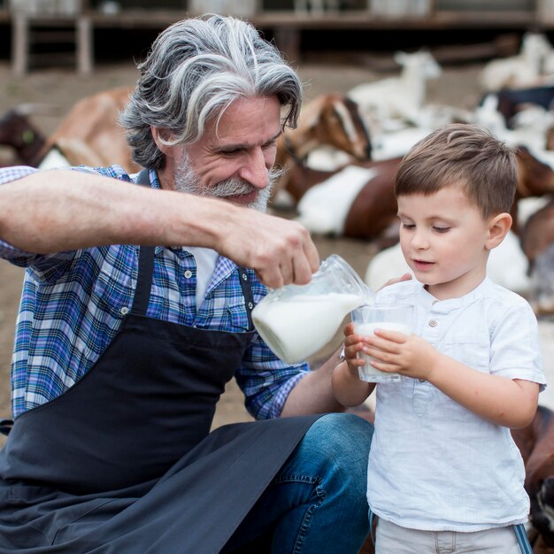 Man giving to boy goat milk