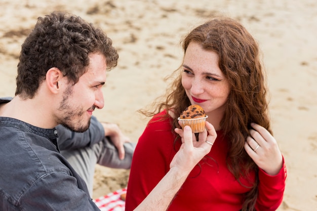 Free photo man giving cupcake to woman