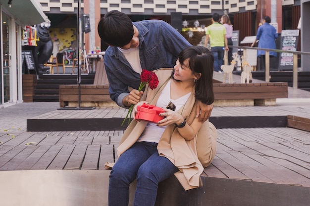 Man giving flowers to a girl in the street