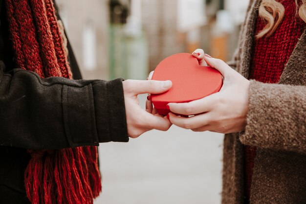 Man giving heart shaped present to woman