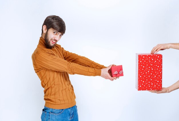 그의 작은 빨간색 선물 상자를주고 큰 선물을받는 사람.