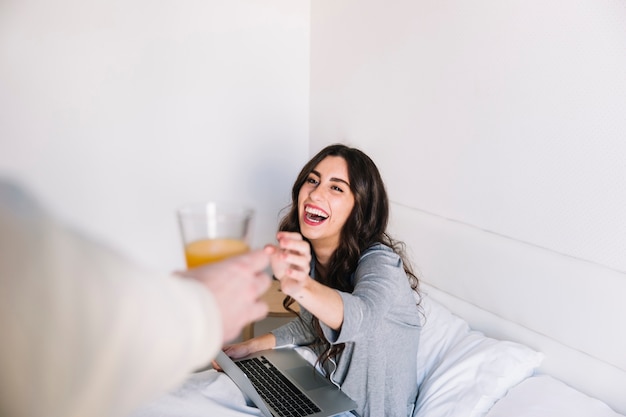 Free photo man giving juice to laughing woman