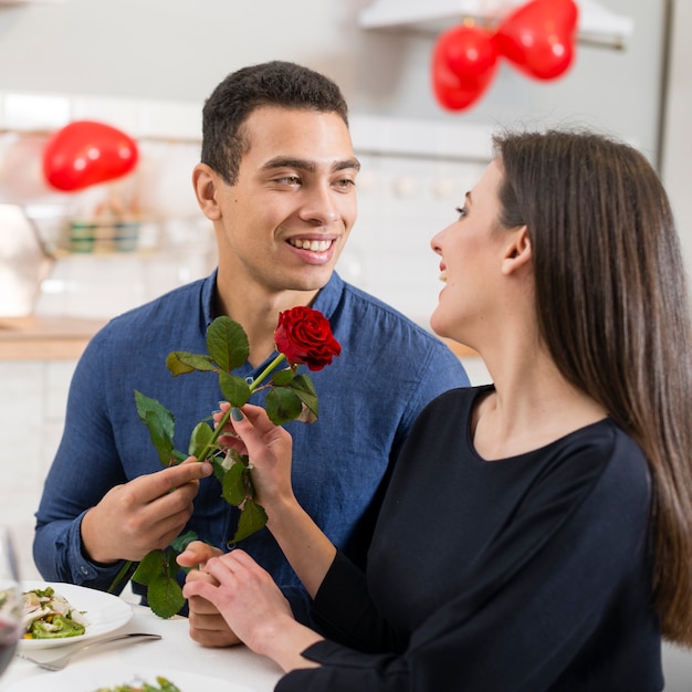 Man giving a rose to his beautiful girlfriend on valentine's day