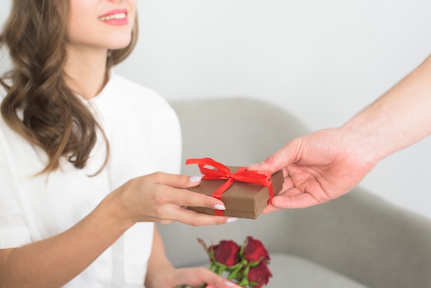 Man giving small gift box to woman
