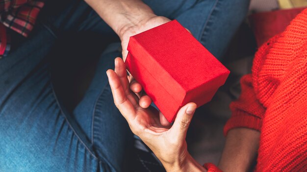 man giving small gift box to woman 