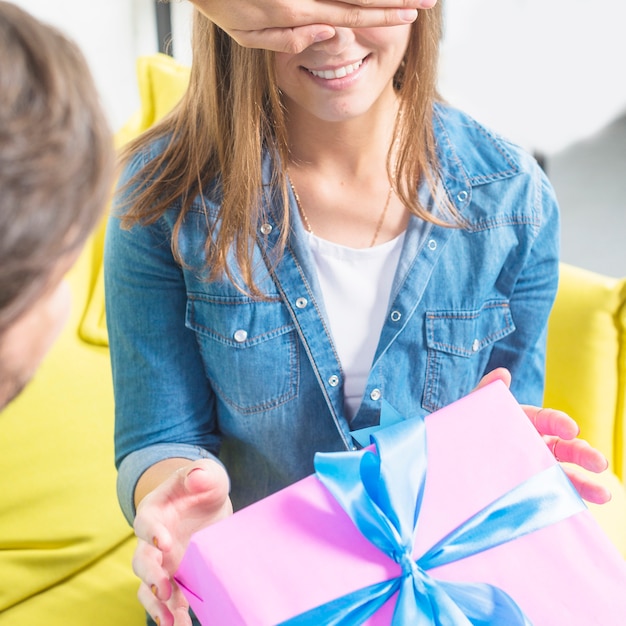 Free photo man giving surprise gift to his girlfriend