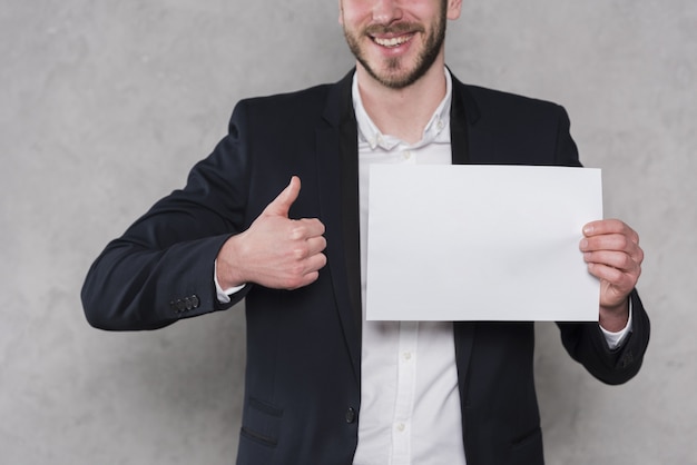 Man giving thumbs up and holding blank paper