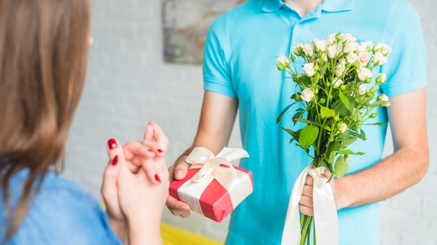 무료 사진 그의 아내에게 발렌타인 선물과 꽃을주는 사람