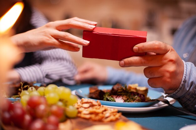 妻のギフトボックスを与え、一緒にロマンチックな夕食を食べている男