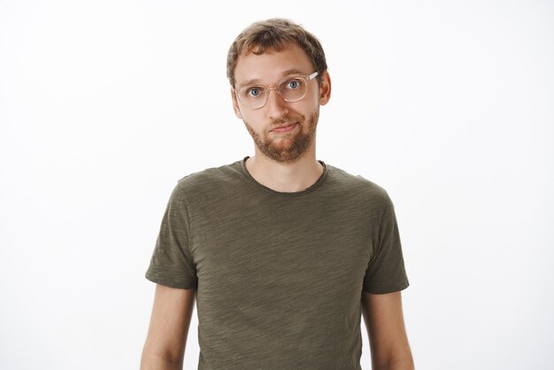 Man in glasses and green casual t-shirt smiling friendly standing relaxed and calm