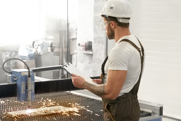 Man in glasses and helmet looking at plasma cuttingv