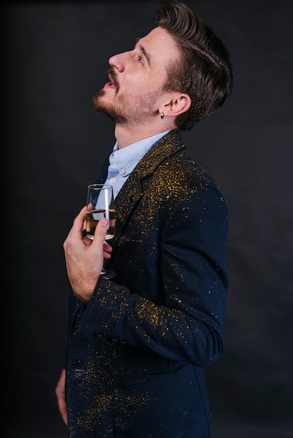 Man in glitter powder standing with champagne glass