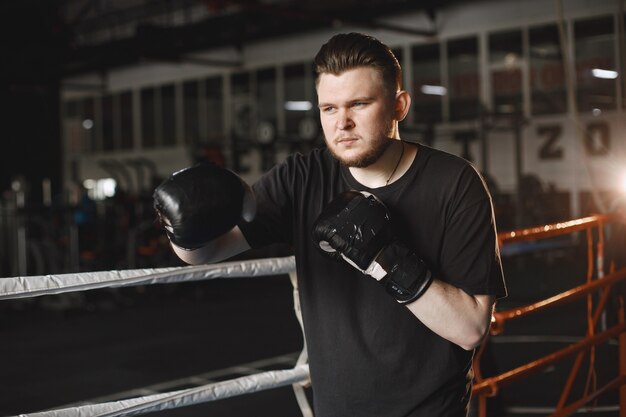 Man in a gloves. Boxer in a sport clothes. Guy with a beard.