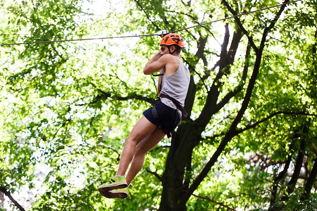 Man goes down on the rope in an entertainment park