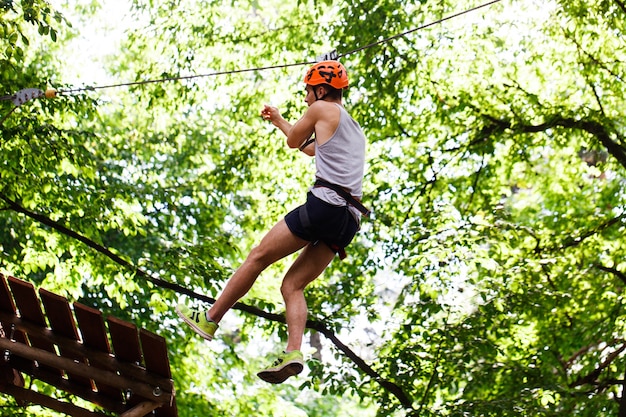 Man goes down on the rope in an entertainment park