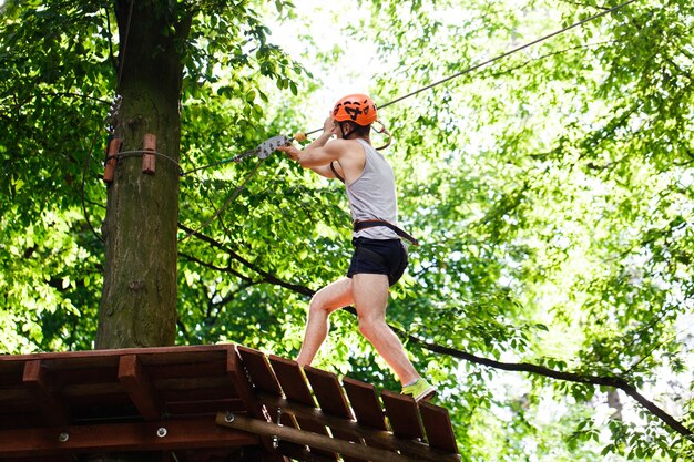 Man goes down on the rope in an entertainment park