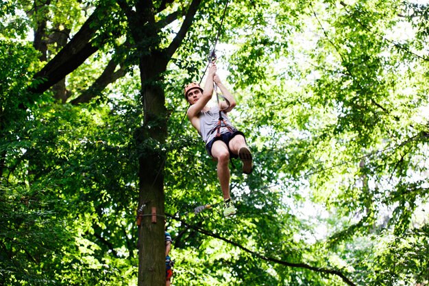 Man goes down on the rope in an entertainment park