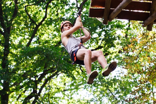 Man goes down on the rope in an entertainment park